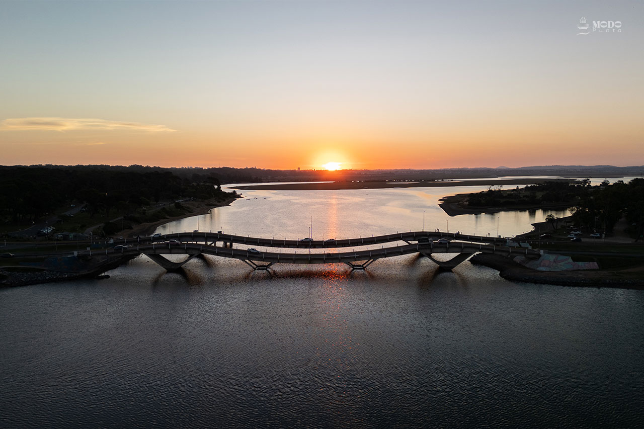 El atardecer sobre el Puente de La Barra acompaña una forma de vida más pausada, sin resignar cercanía urbana.