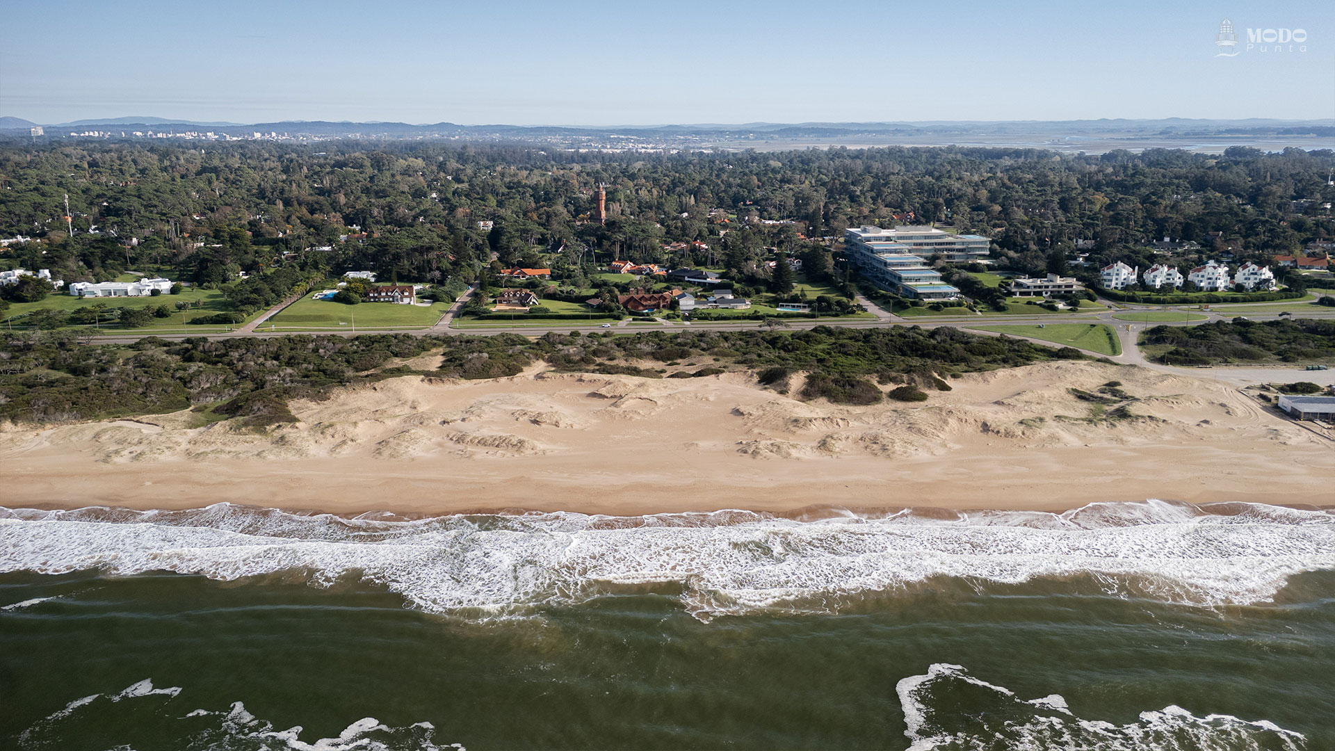 Vista desde el mar: la primera línea frente a Playa Brava se recorta sobre un entorno natural y abierto, donde Acqua se integra con su silueta escalonada frente al océano.