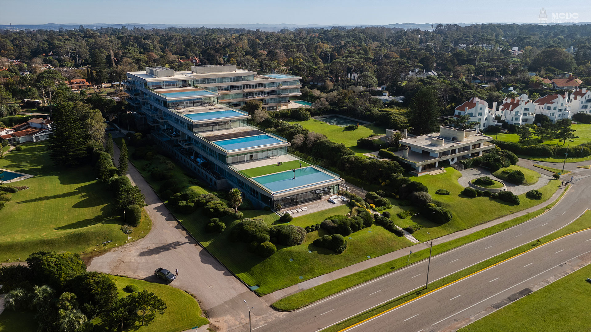 Acqua en primer plano: las terrazas escalonadas despliegan piscinas infinitas privadas que se funden con el horizonte del Atlántico, diluyendo los límites entre arquitectura y paisaje.