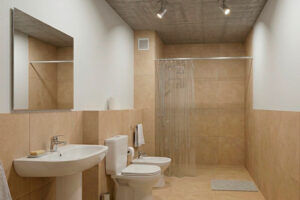 Baño completo con revestimientos cerámicos de alto tránsito y grifería monocomando.